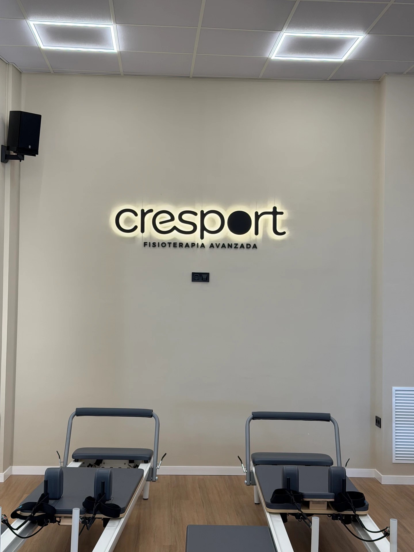 Rótulo iluminado de Cresport Fisioterapia Avanzada en la sala de reformers